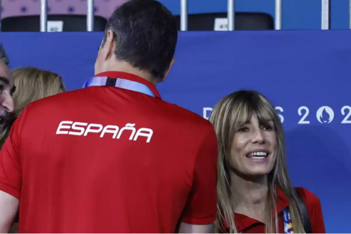 Personas con camisetas rojas de España conversando en un evento deportivo.