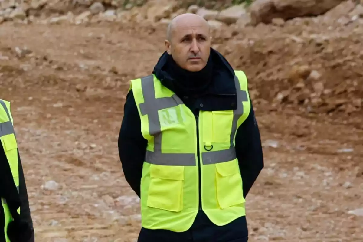 A man with a yellow reflective vest at a construction site.