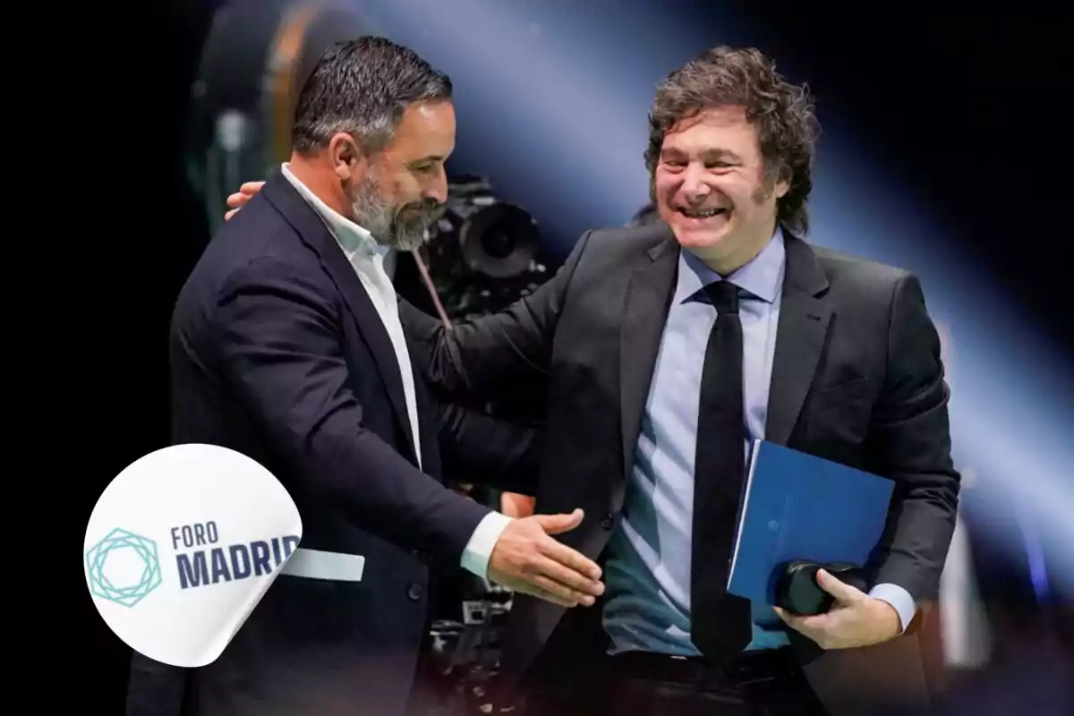 Dos hombres estrechándose la mano y sonriendo en un evento con el logo de Foro Madrid en primer plano.