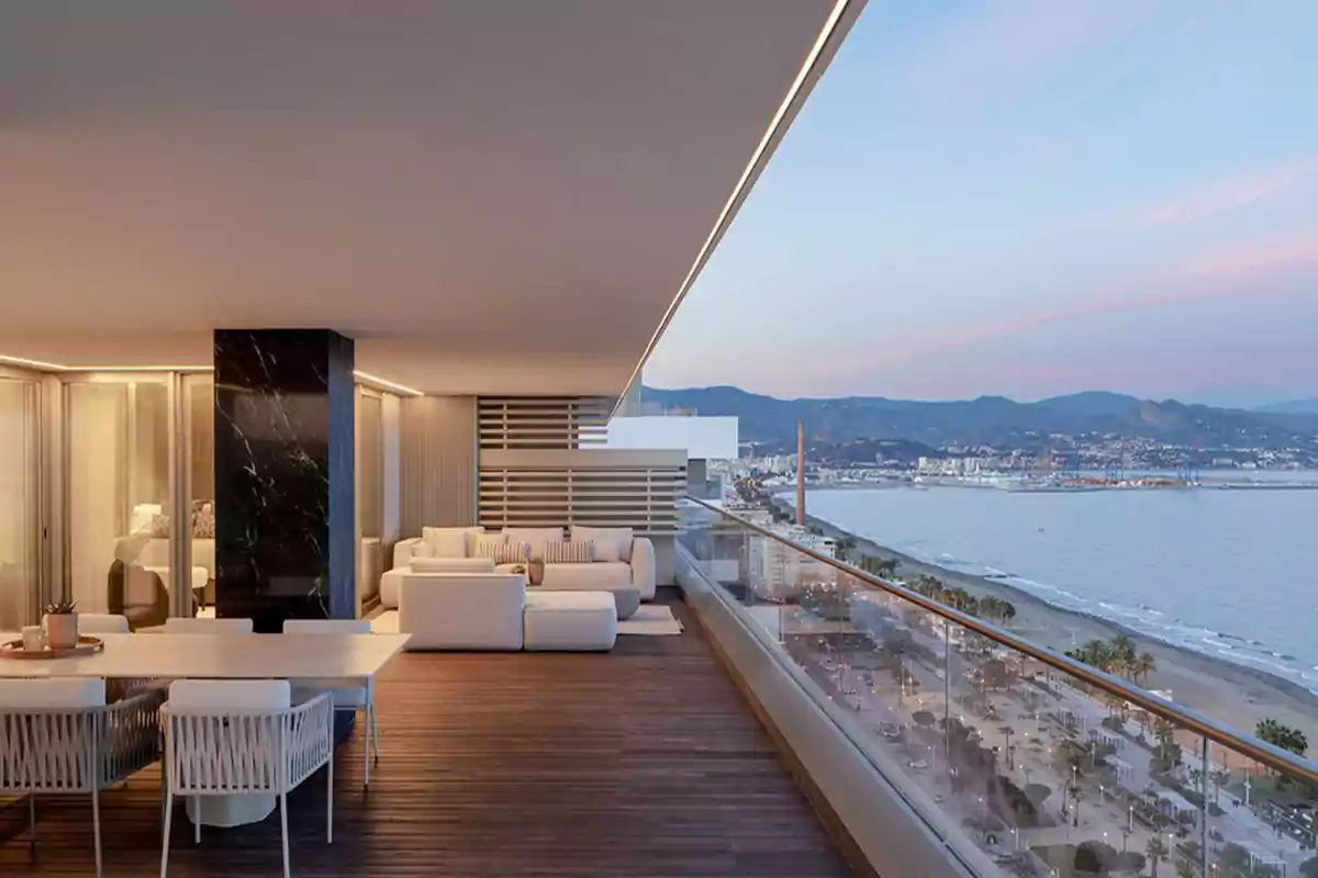 Terraza moderna con muebles blancos y vista panorámica al mar y la ciudad.