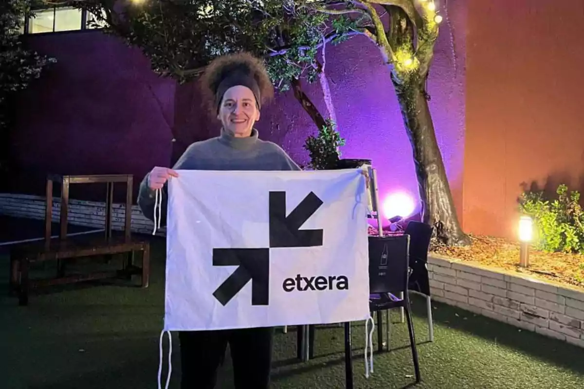 Una persona sostiene una bandera blanca con flechas negras y la palabra Una persona sostiene una bandera blanca con flechas negras y la palabra