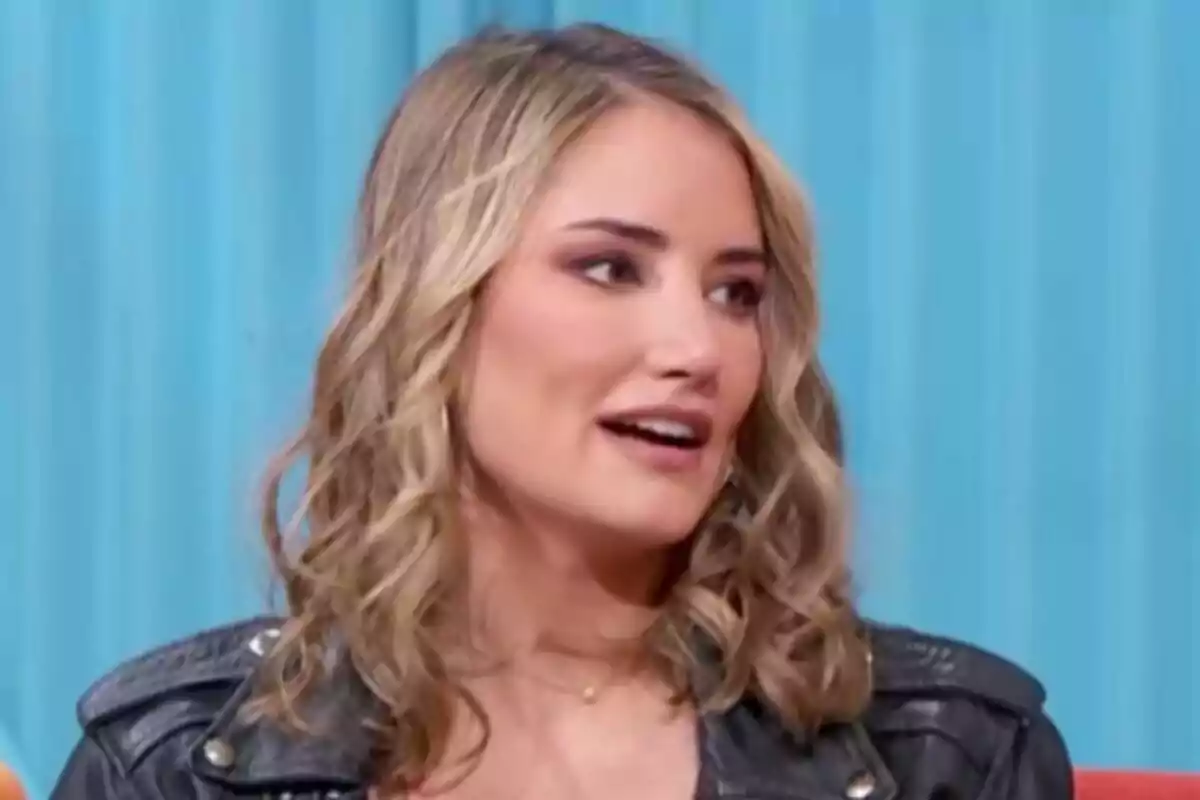 Alba Carrillo con cabello rubio y rizado lleva una chaqueta de cuero negra y está hablando frente a un fondo azul en Mañaneros. Alba Carrillo con cabello rubio y rizado lleva una chaqueta de cuero negra y está hablando frente a un fondo azul en Mañaneros.