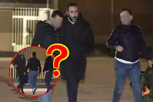 Tres personas caminando juntas en un entorno urbano por la noche, con una de ellas destacada en un círculo rojo con un signo de interrogación.