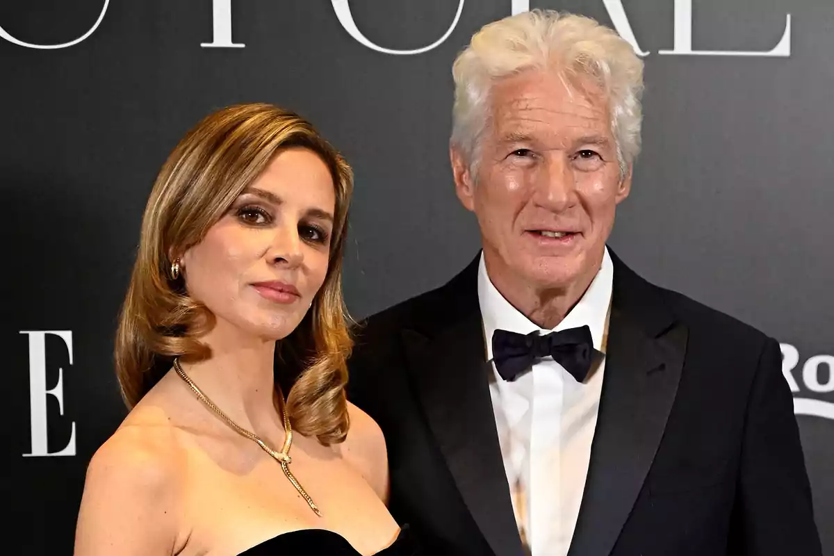 Alejandra Silva y Richard Gere elegantemente vestida posa en un evento formal con fondo oscuro. Alejandra Silva y Richard Gere elegantemente vestida posa en un evento formal con fondo oscuro.