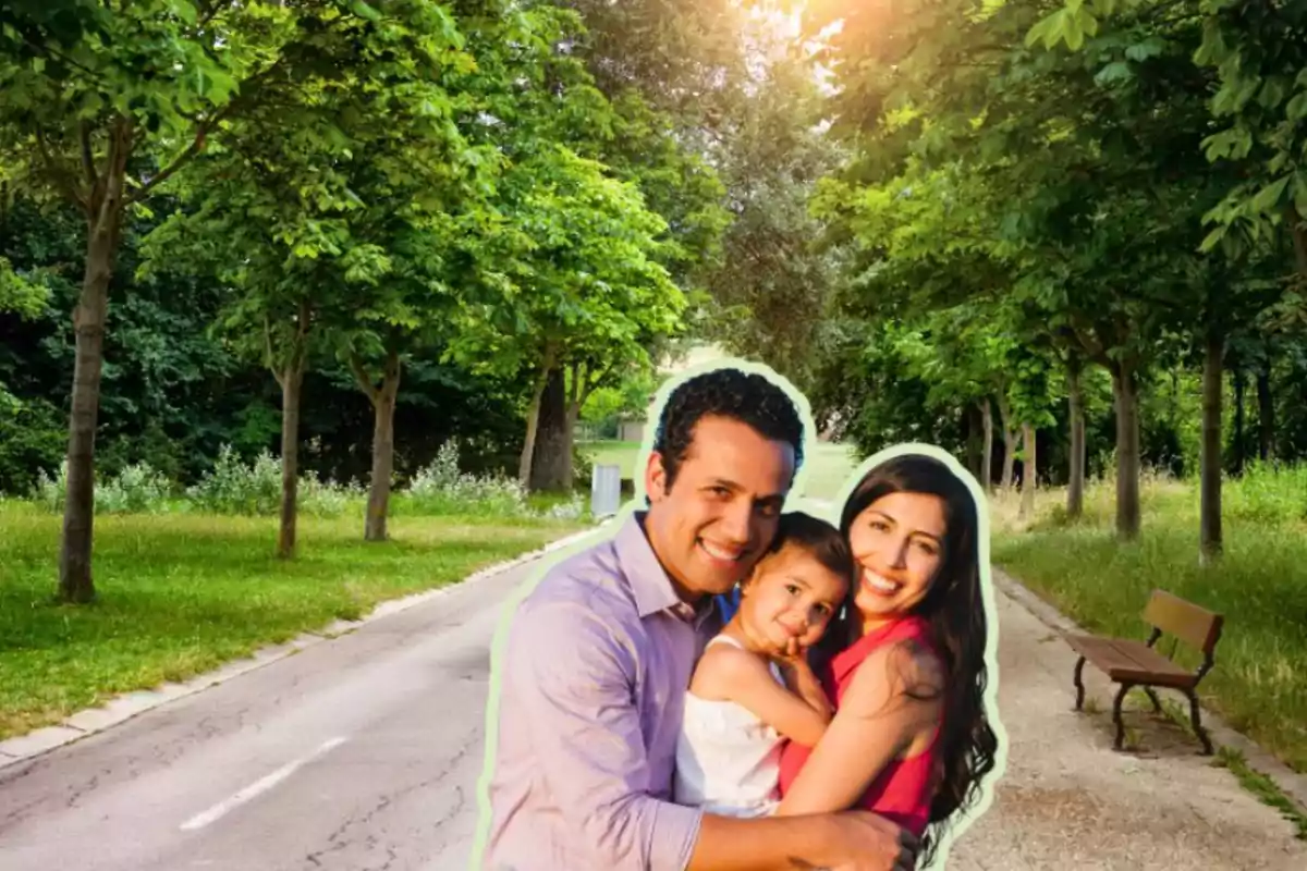 Una familia abrazándose en un camino rodeado de árboles en un parque.