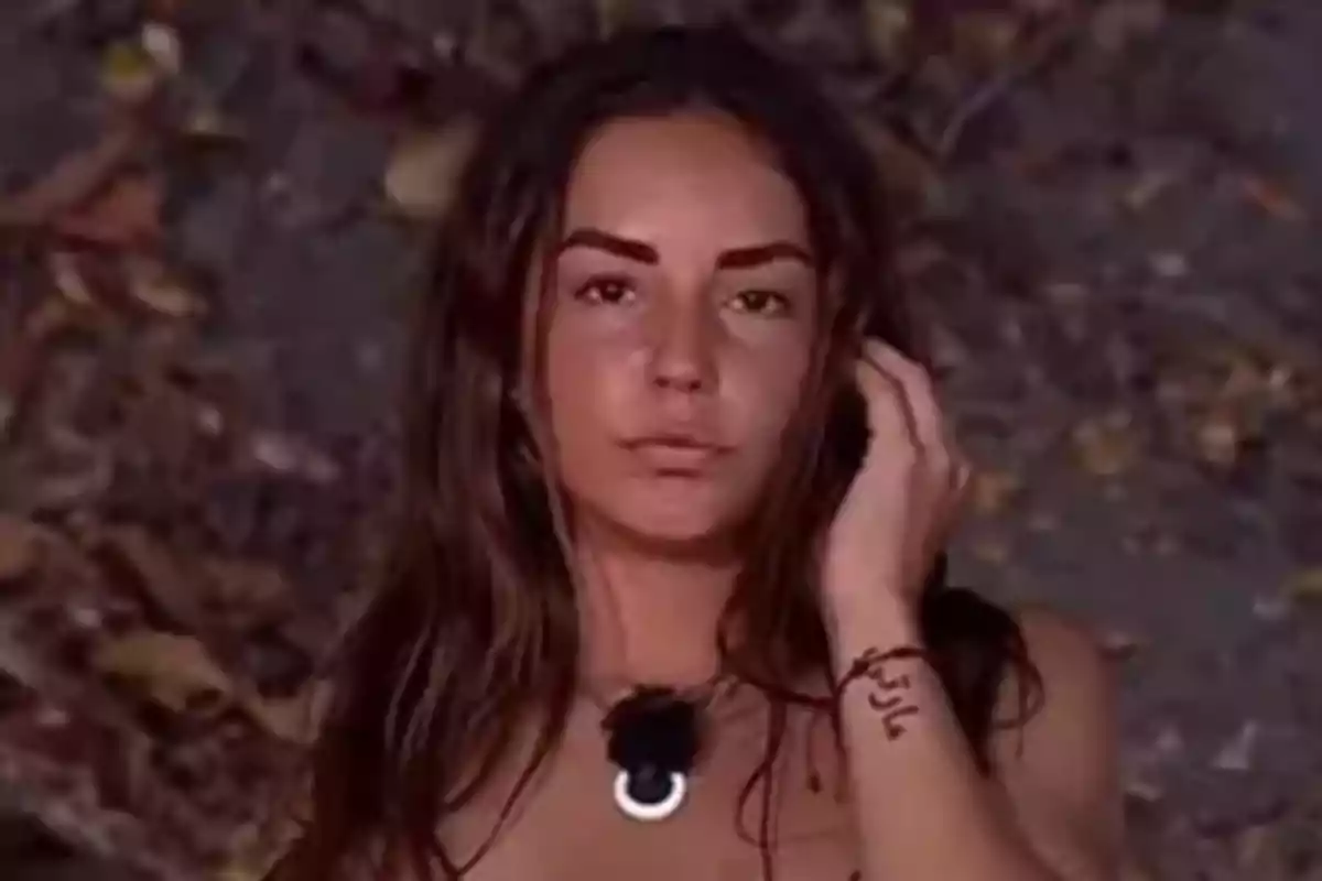 Primer plano de Anita Williams con cabello largo y oscuro mientras está en 'Supervivientes' con un fondo de hojas secas. Primer plano de Anita Williams con cabello largo y oscuro mientras está en 'Supervivientes' con un fondo de hojas secas.