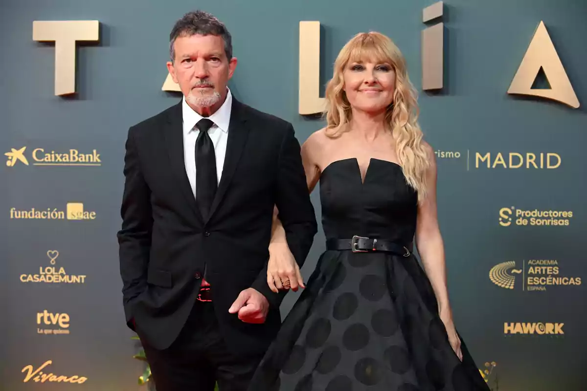 Antonio Banderas y Cayetana Guillén Cuervo elegantemente vestida posa en una alfombra roja frente a un fondo con logotipos de patrocinadores. Antonio Banderas y Cayetana Guillén Cuervo elegantemente vestida posa en una alfombra roja frente a un fondo con logotipos de patrocinadores.