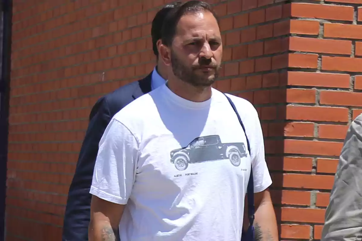 Antonio Tejado con camiseta blanca con diseño de coche camina frente a una pared de ladrillos. Antonio Tejado con camiseta blanca con diseño de coche camina frente a una pared de ladrillos.