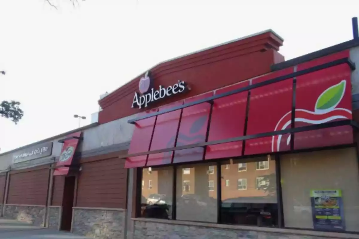 Facade of an Applebee's restaurant with an exterior design in red tones and an apple logo. Facade of an Applebee's restaurant with an exterior design in red tones and an apple logo.