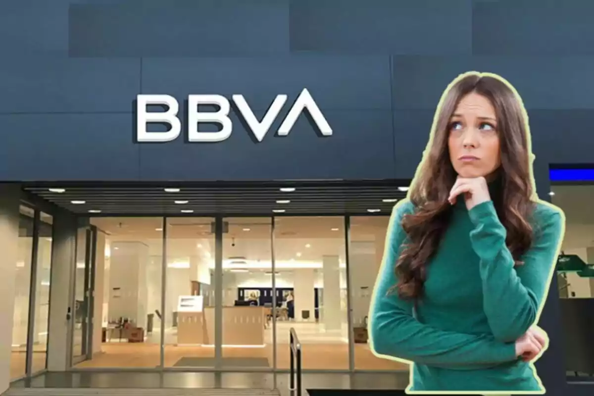 Una mujer pensativa frente a una sucursal del banco BBVA.