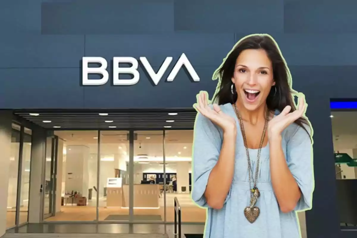 Mujer sonriente frente a una sucursal del banco BBVA.