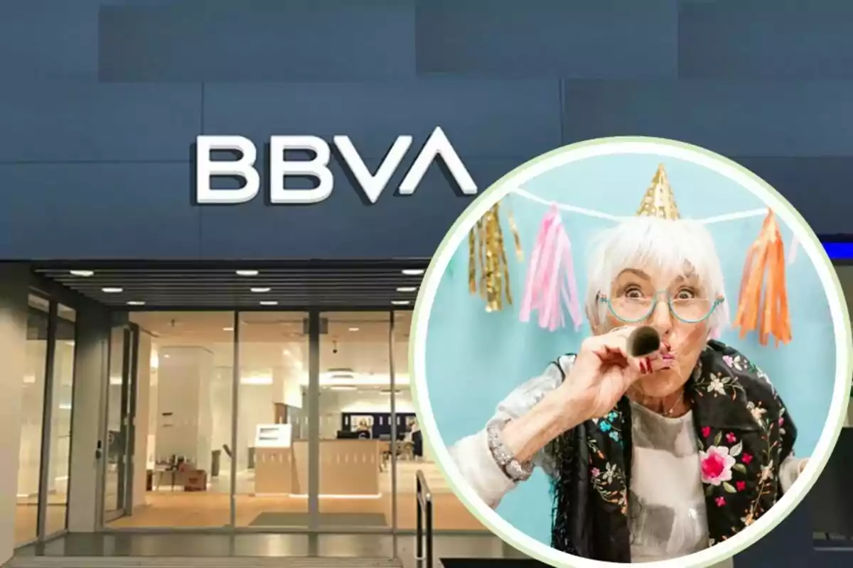 Fachada de una sucursal de BBVA con una imagen circular de una mujer mayor celebrando una fiesta con un sombrero de cumpleaños y un matasuegras.