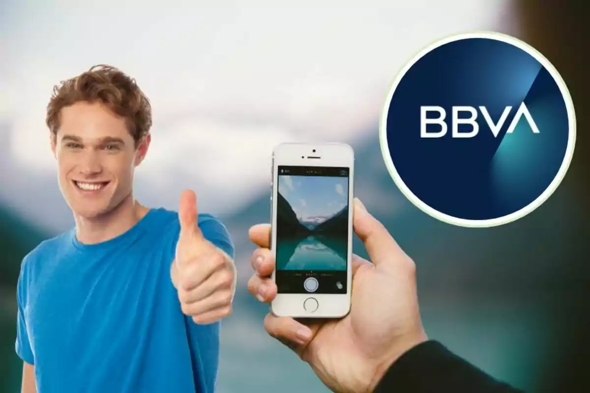 A smiling man in a blue t-shirt giving a thumbs up, one hand holding a mobile phone showing a photo of a landscape and the BBVA logo in the upper right corner.