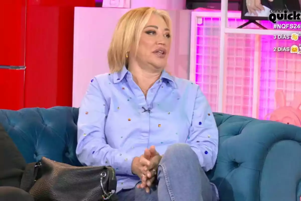 Belén Esteban con cabello rubio y camisa azul está sentada en un sofá azul en un ambiente colorido en 'Ni que fuéramos shhh' Belén Esteban con cabello rubio y camisa azul está sentada en un sofá azul en un ambiente colorido en 'Ni que fuéramos shhh'