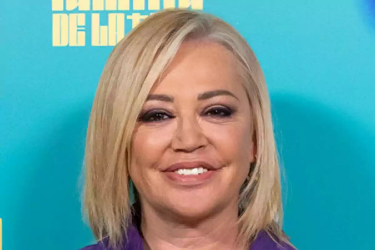 Belén Esteban con cabello rubio y sonrisa frente a un fondo azul en la presentación de La Familia de la Tele. Belén Esteban con cabello rubio y sonrisa frente a un fondo azul en la presentación de La Familia de la Tele.