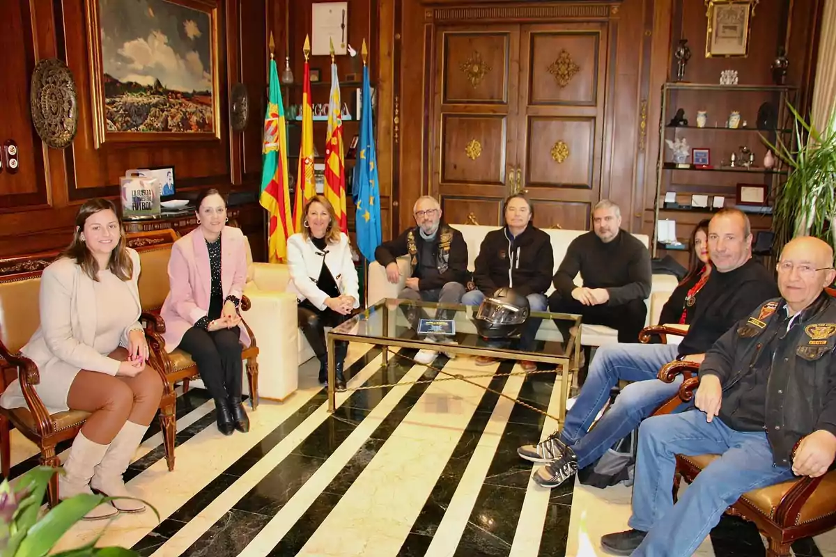 A group of people sitting in an elegant room with wooden walls and flags in the background.