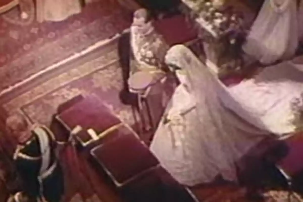 Juan Carlos I and Queen Sofía, dressed formally, are standing in an elegant setting, possibly during a ceremony. Juan Carlos I and Queen Sofía, dressed formally, are standing in an elegant setting, possibly during a ceremony.