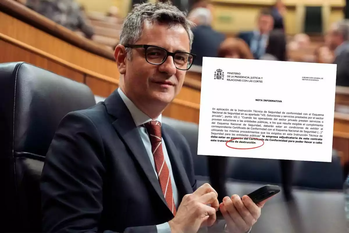 Un hombre con gafas y traje oscuro sostiene un teléfono móvil en un entorno de oficina o sala de conferencias, con un documento ampliado en primer plano que tiene texto subrayado en rojo.