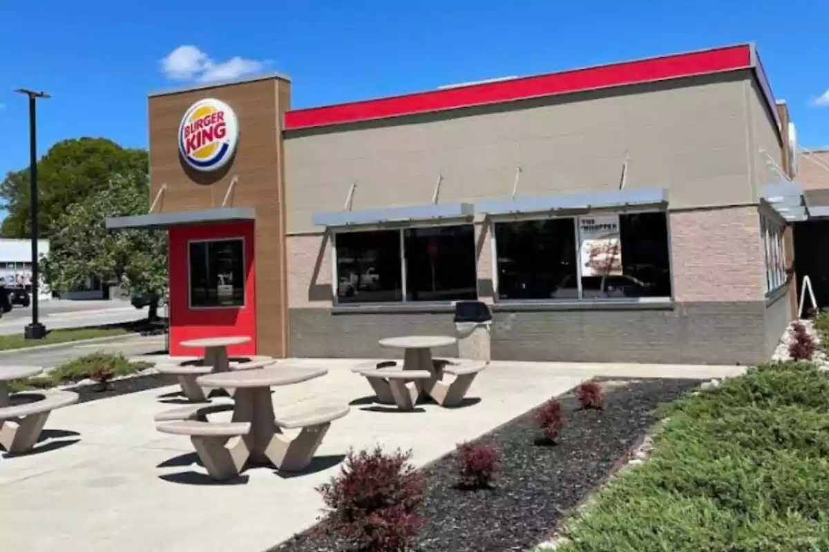 Fast food restaurant Burger King with outdoor concrete tables and a clear sky