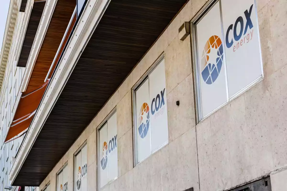 Fachada de un edificio con ventanas que muestran el logo de Cox Energy.