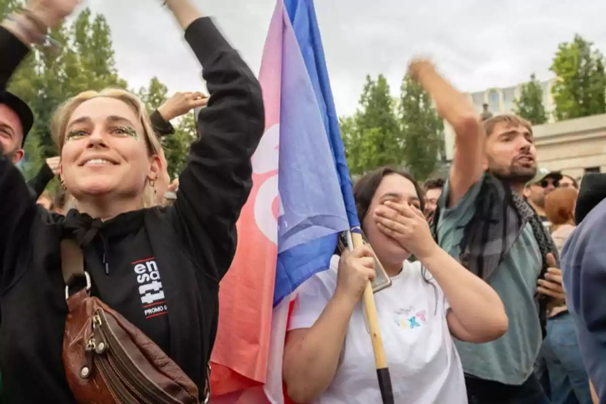 Personas celebrando en una manifestación con banderas y expresiones de alegría.