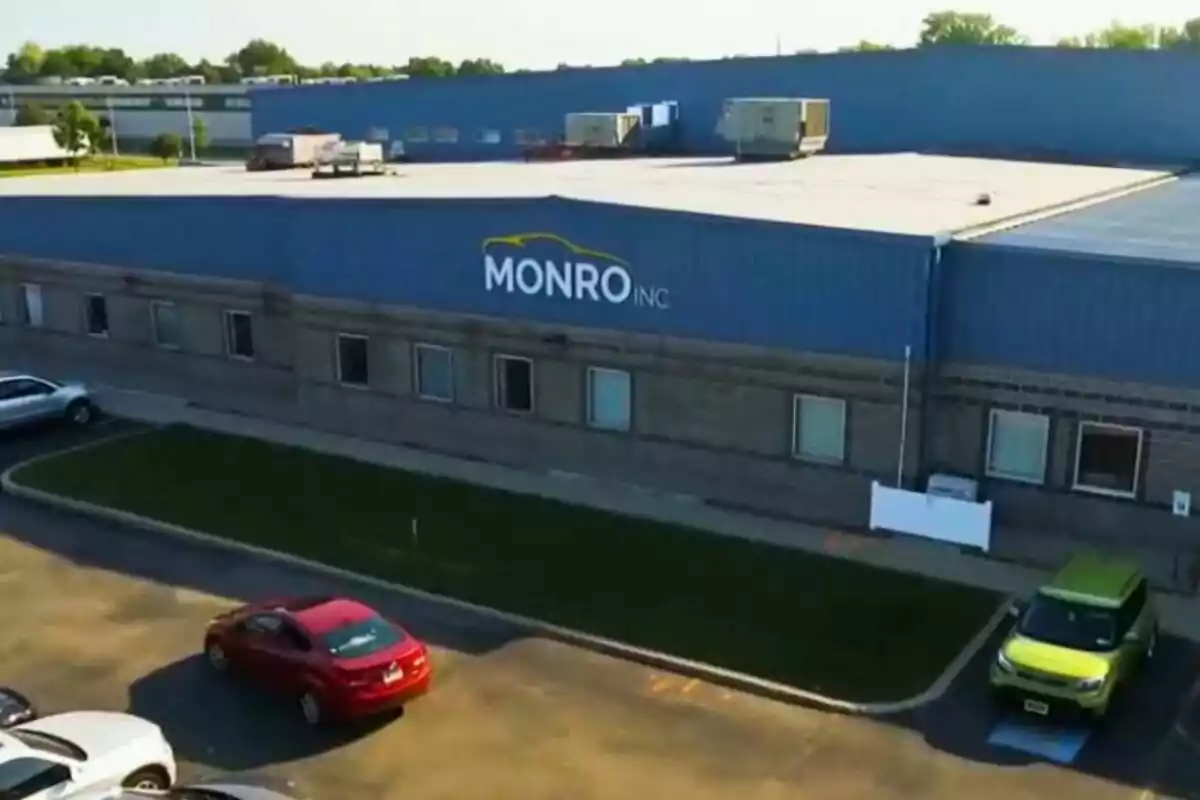 Blue industrial building with the Monro Inc logo on the facade and several cars parked in front Blue industrial building with the Monro Inc logo on the facade and several cars parked in front