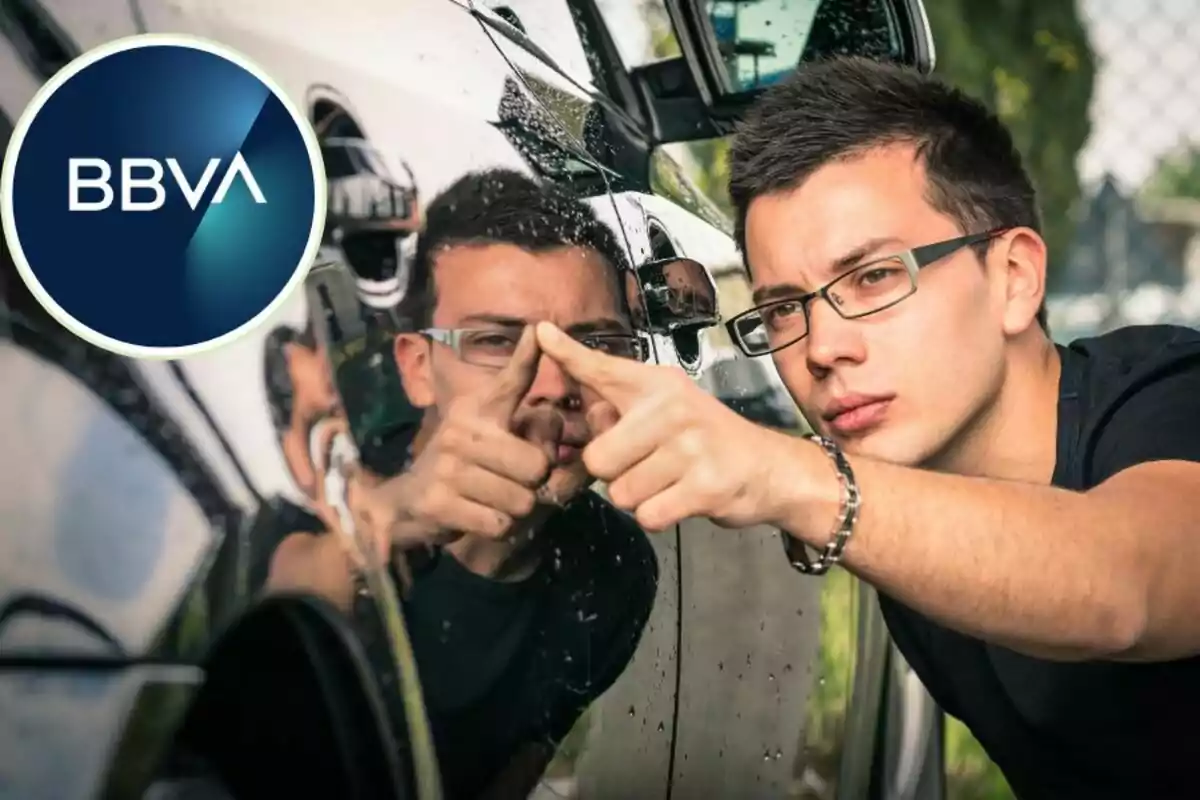 Un hombre con gafas inspecciona de cerca la superficie de un automóvil, mientras el logo de BBVA aparece en la esquina superior izquierda de la imagen. Un hombre con gafas inspecciona de cerca la superficie de un automóvil, mientras el logo de BBVA aparece en la esquina superior izquierda de la imagen.