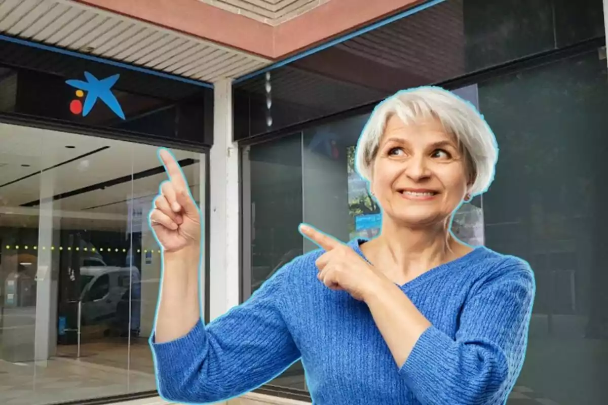 Mujer mayor sonriendo y señalando hacia el logotipo de una entidad bancaria en la entrada de un edificio. Mujer mayor sonriendo y señalando hacia el logotipo de una entidad bancaria en la entrada de un edificio.