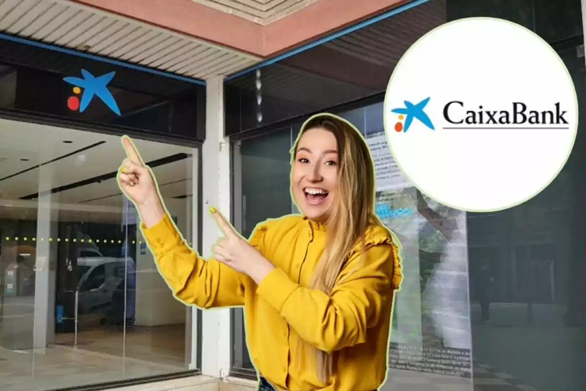 Una mujer sonriente con una camisa amarilla señala hacia el logotipo de CaixaBank en una sucursal bancaria.