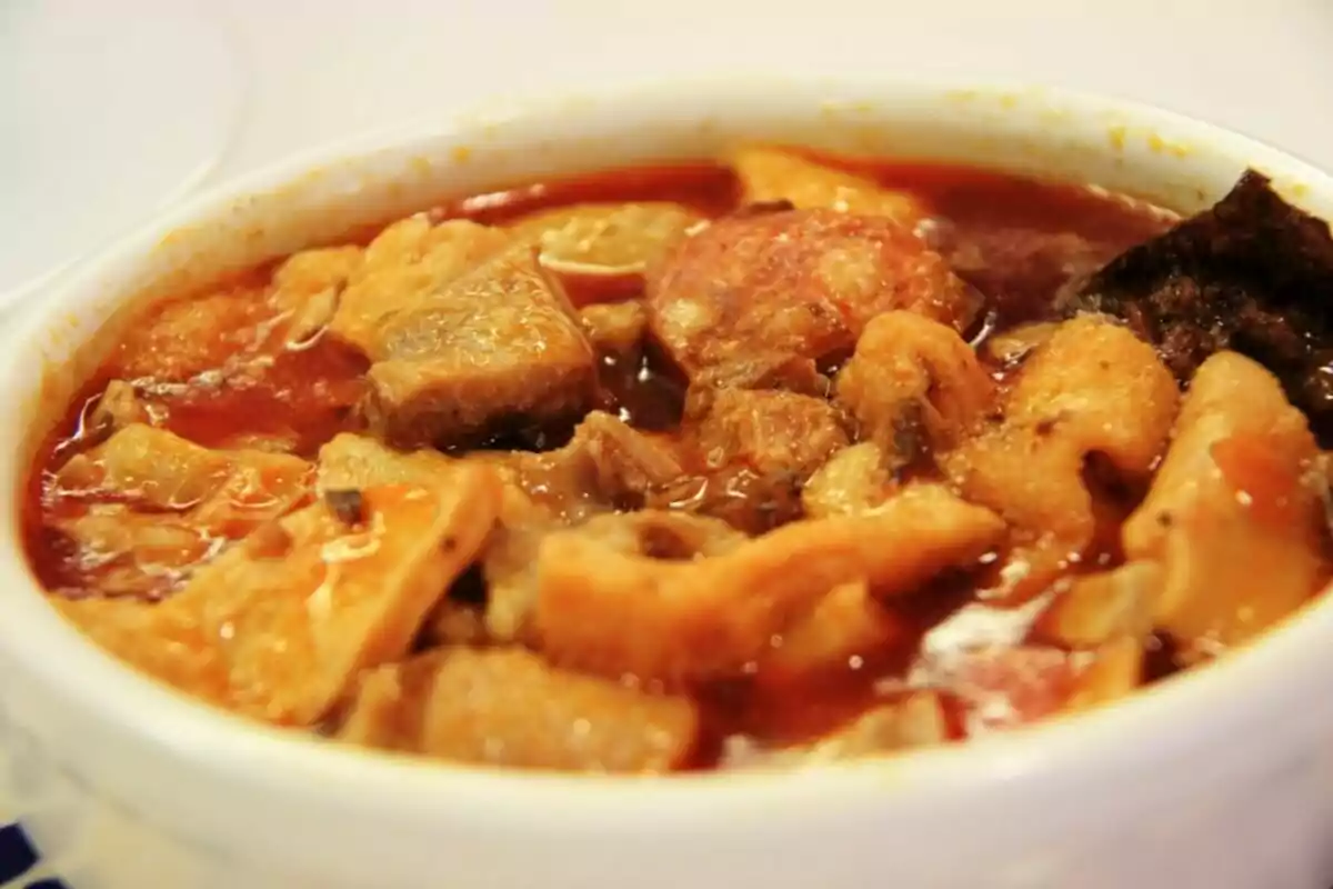 Un plato de menudo servido en un tazón blanco.