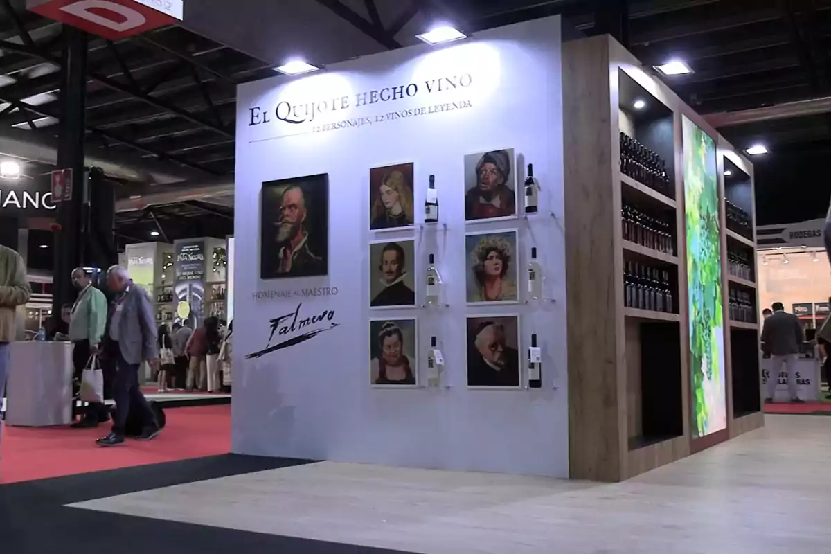 Un stand de exhibición en una feria de vinos presenta una temática inspirada en El Quijote, con retratos de personajes y botellas de vino expuestas en la pared. Un stand de exhibición en una feria de vinos presenta una temática inspirada en El Quijote, con retratos de personajes y botellas de vino expuestas en la pared.