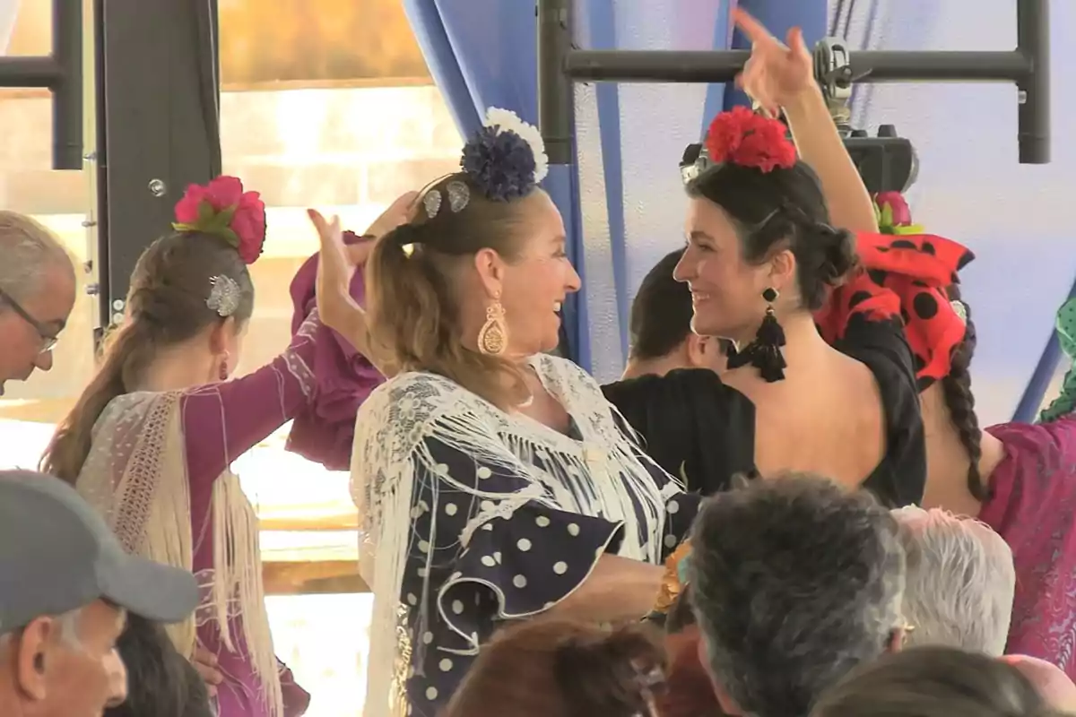 Personas bailando flamenco con trajes tradicionales y adornos en el cabello en un ambiente festivo. Personas bailando flamenco con trajes tradicionales y adornos en el cabello en un ambiente festivo.
