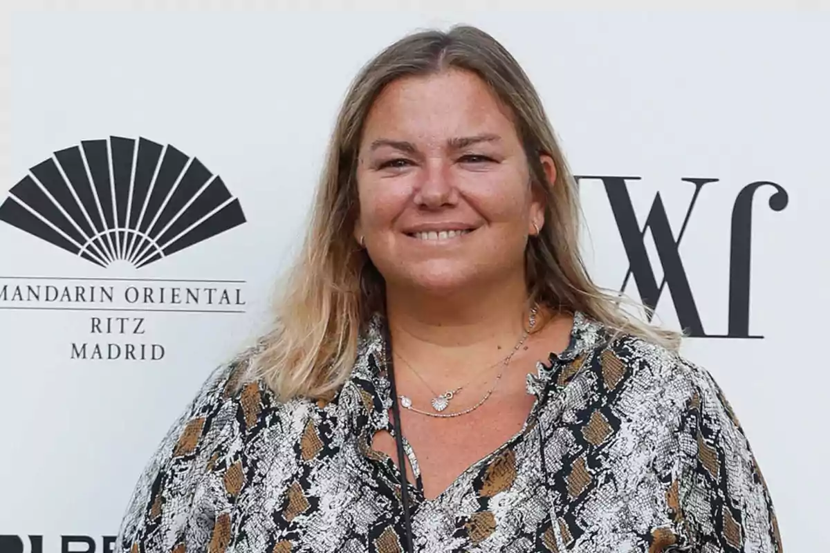 Mujer sonriendo frente a un fondo con logotipos de Mandarin Oriental Ritz Madrid y WF.