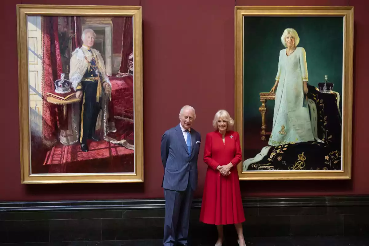 King Charles III and Queen Camilla pose in front of two framed portraits depicting a man and a woman dressed in formal and elegant attire. King Charles III and Queen Camilla pose in front of two framed portraits depicting a man and a woman dressed in formal and elegant attire.