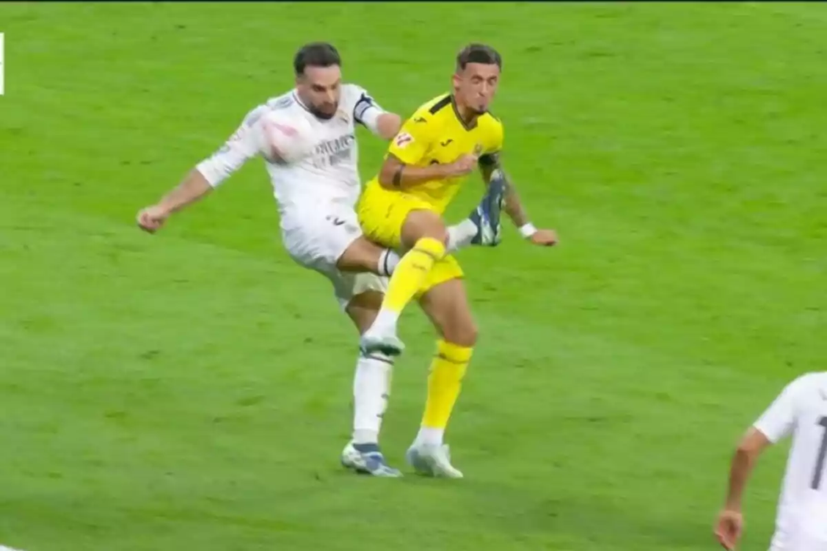 Dos jugadores de fútbol compiten por el balón en el campo.