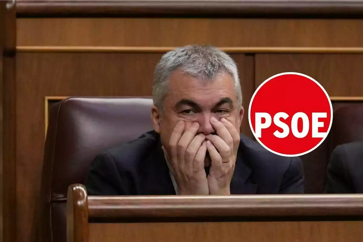 Hombre de cabello canoso sentado en un escaño con las manos en la cara y un círculo rojo con las letras PSOE a su lado