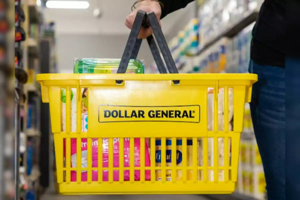 A person holds a yellow Dollar General shopping basket full of products in a store aisle. A person holds a yellow Dollar General shopping basket full of products in a store aisle.