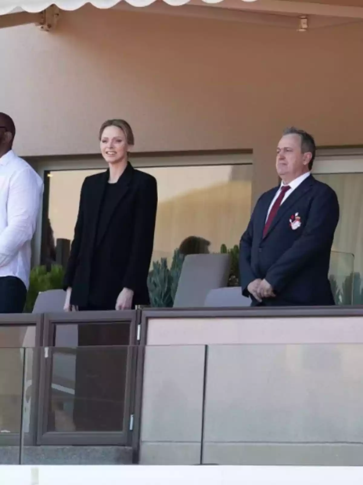 A group of people is standing on a balcony, watching something intently. A group of people is standing on a balcony, watching something intently.