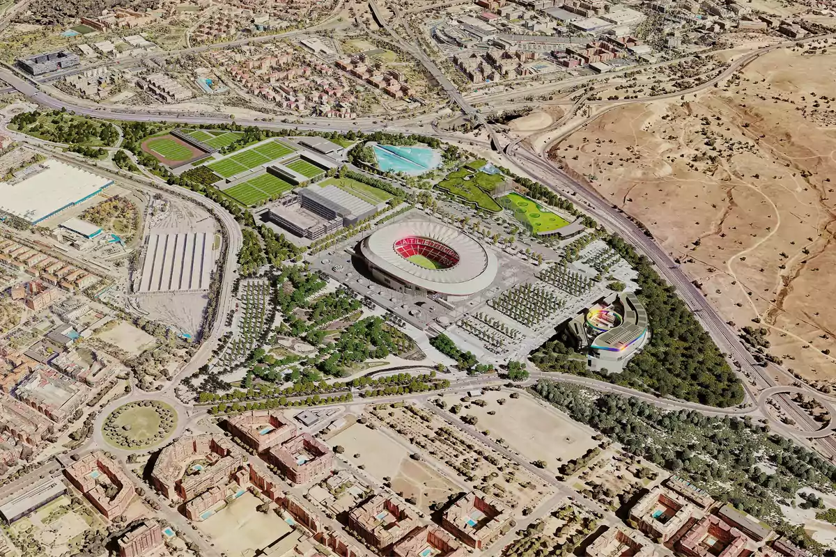 Vista aérea de un estadio de fútbol rodeado de instalaciones deportivas, áreas verdes y una ciudad.