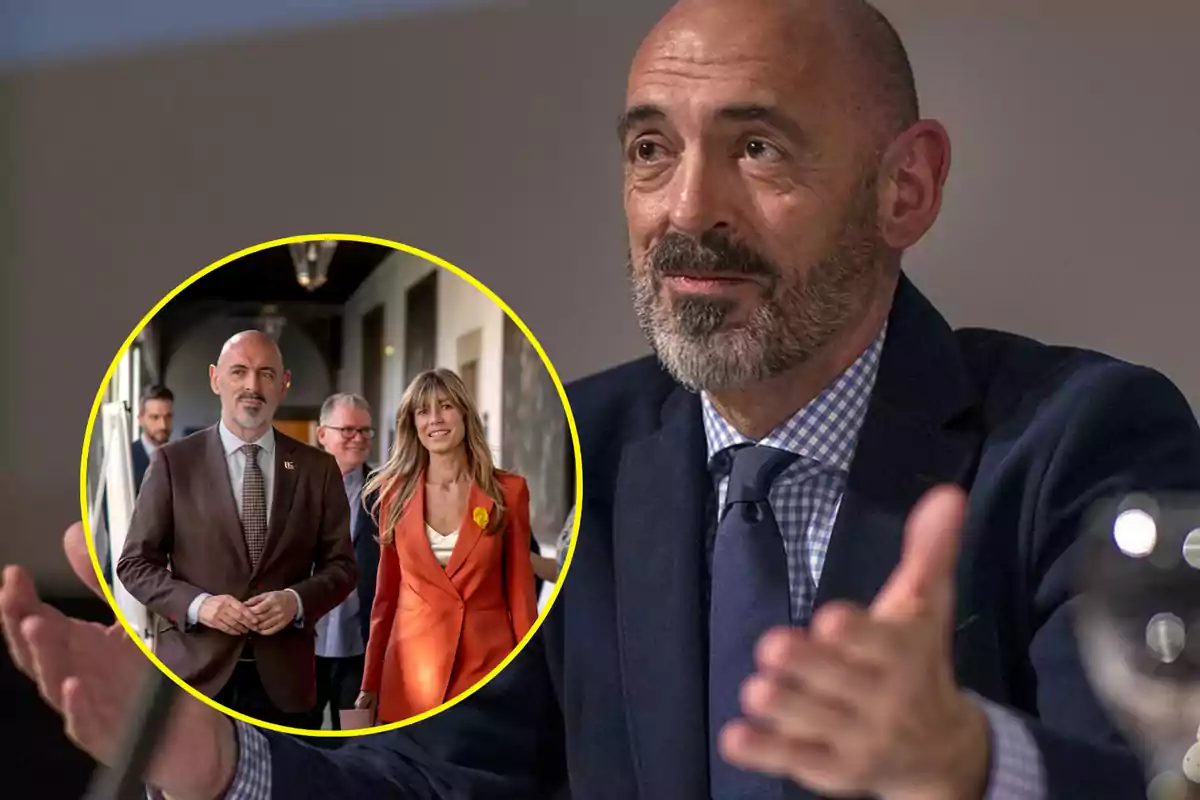 Un hombre calvo con barba y traje oscuro gesticula mientras habla, con una imagen circular insertada que muestra a la misma persona junto a una mujer rubia con traje naranja y otras personas en un pasillo.