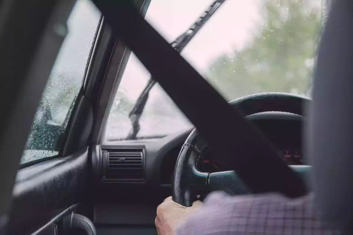 Una persona al volante de un coche, conduciendo