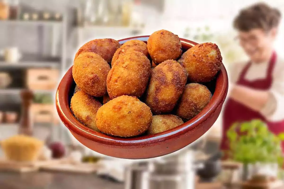 Plato de croquetas con el fondo de una mujer cocinando