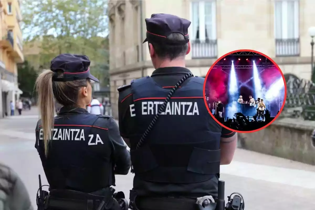 Dos agentes de la Ertzaintza de espaldas en una calle, con un recuadro que muestra un concierto con luces y humo.