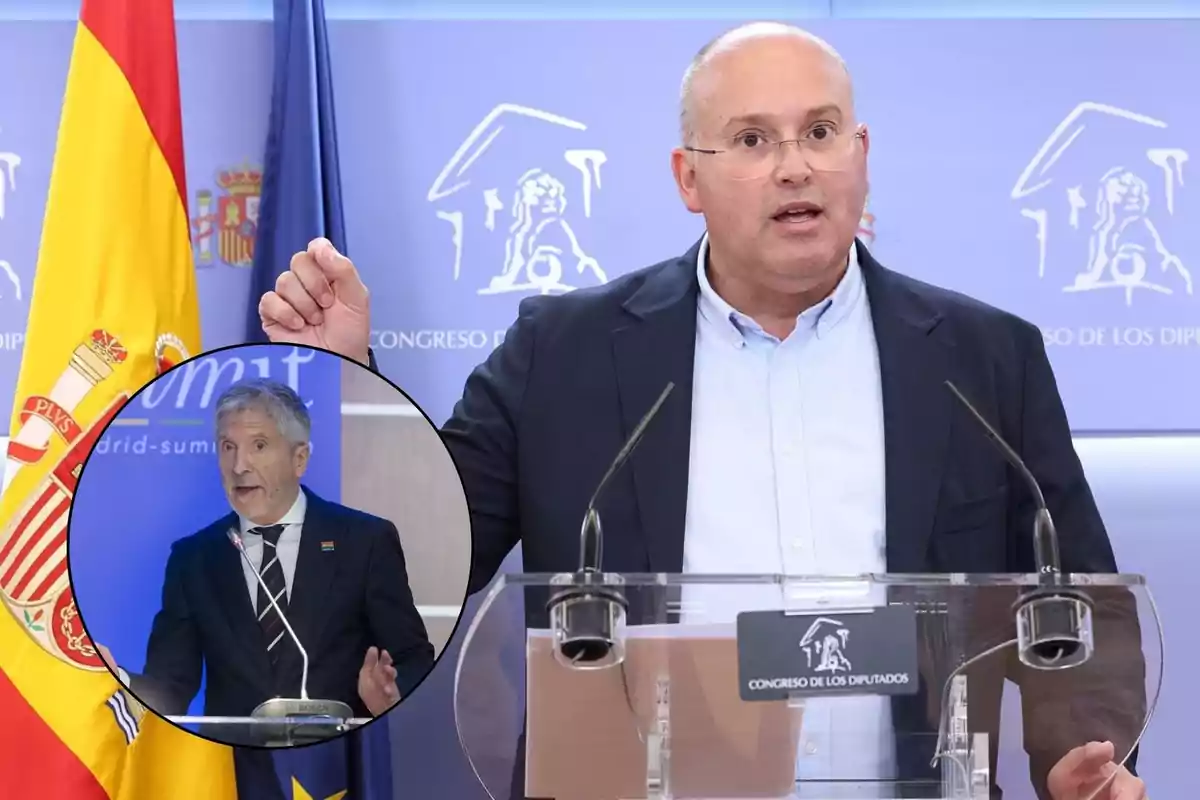 Un hombre hablando en una conferencia de prensa con una bandera de España y una bandera de la Unión Europea detrás de él, con una imagen insertada de otro hombre hablando en un evento diferente.