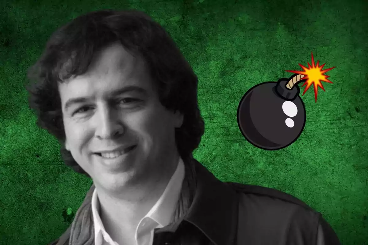 Un hombre sonriente con cabello rizado y una chaqueta oscura, junto a una ilustración de una bomba con mecha encendida, sobre un fondo verde texturizado.