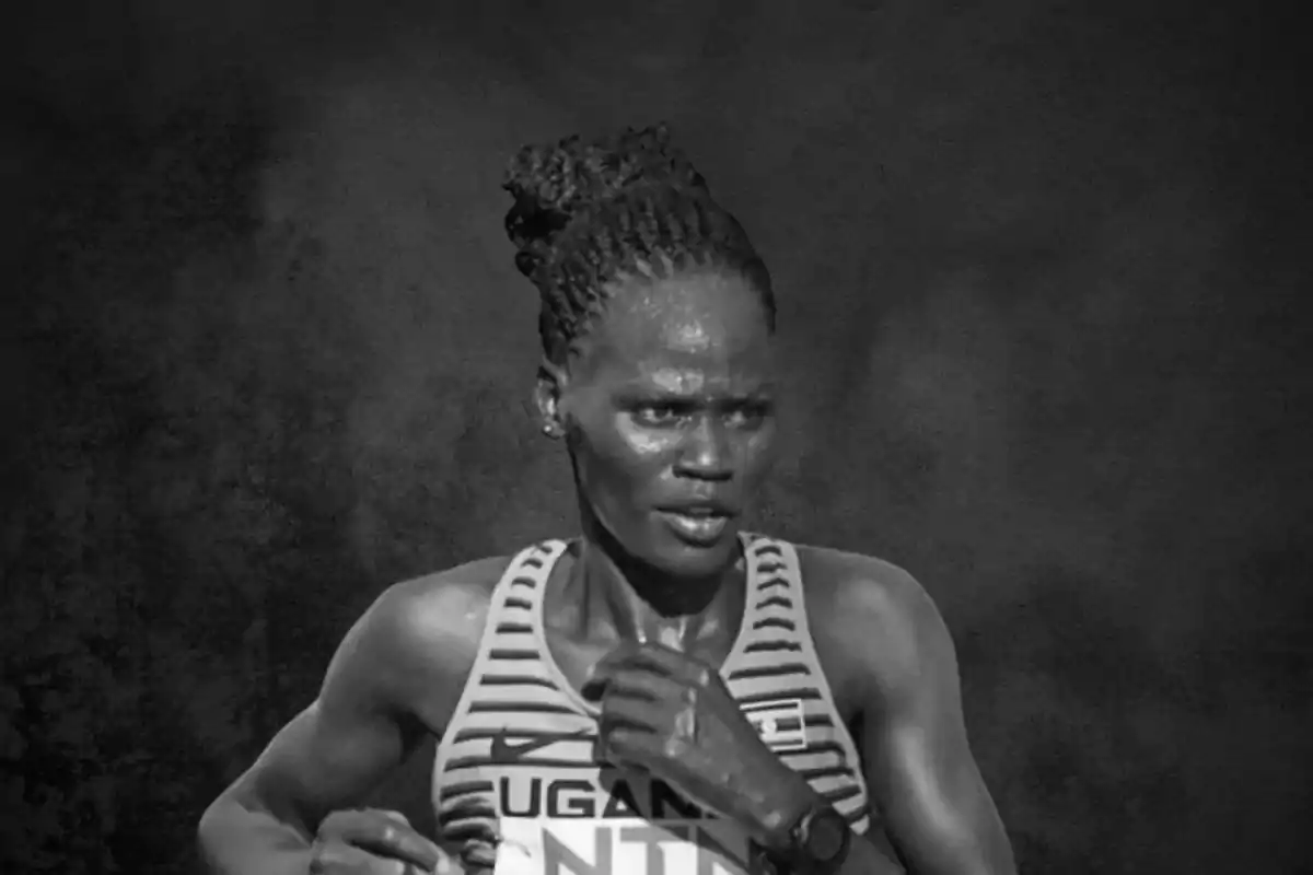 Atleta corriendo con camiseta de Uganda en fondo oscuro.