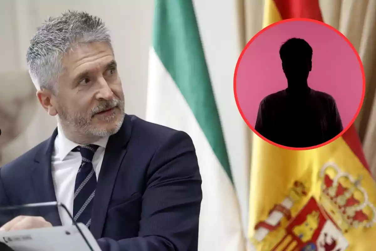 Un hombre de cabello canoso y barba mira hacia un círculo rojo con una silueta negra sobre un fondo rosa; detrás de él hay banderas de España e Italia.