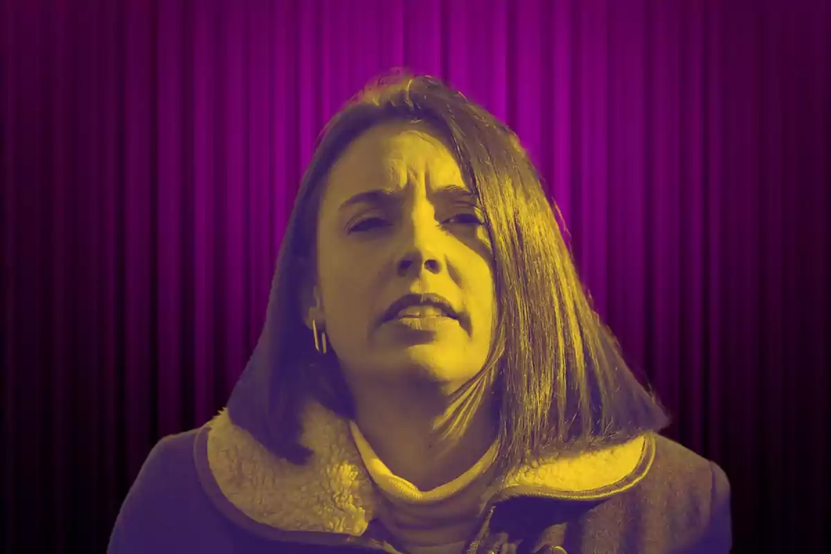 A person with a yellow effect on a background of purple curtains.