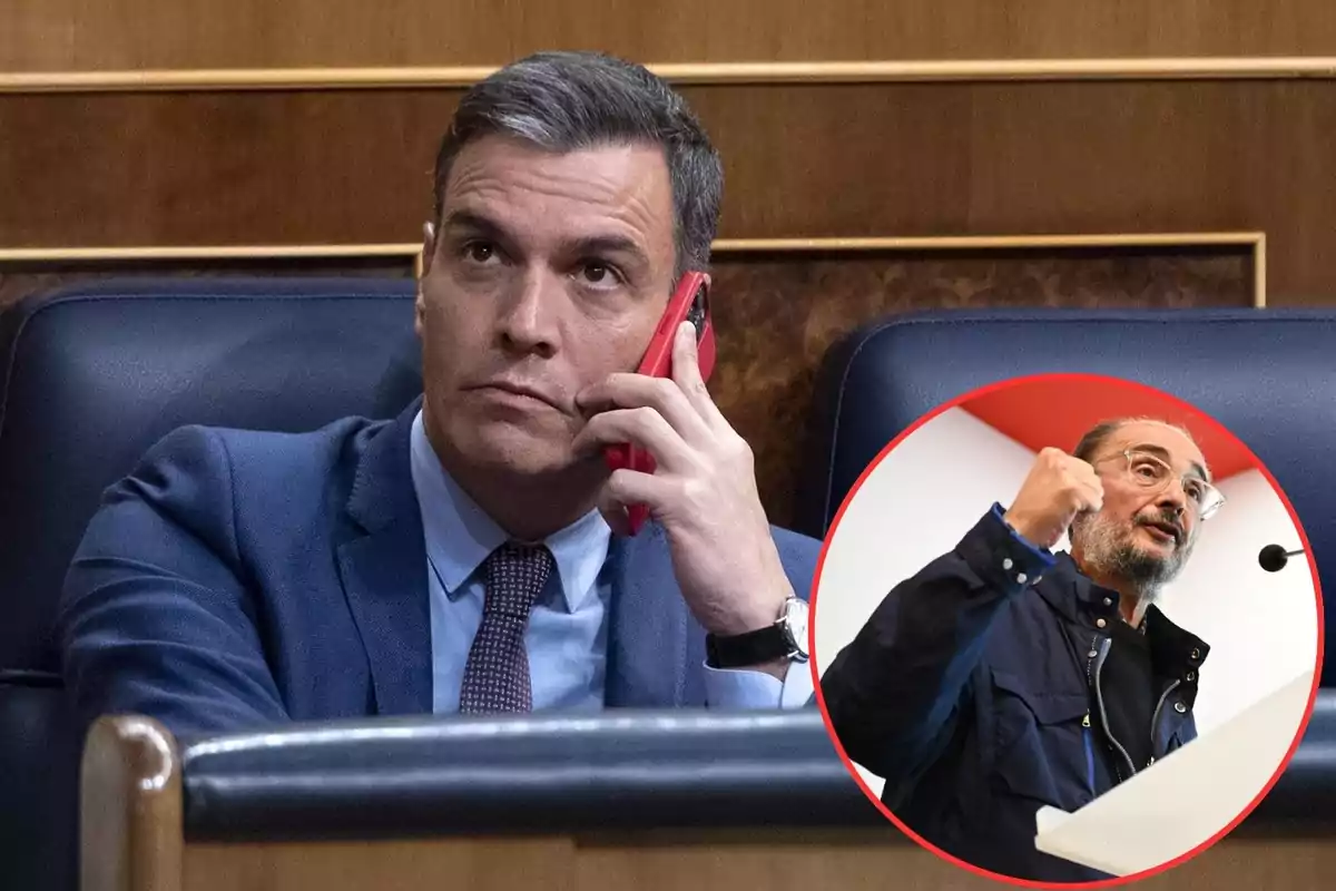 Un hombre en traje hablando por teléfono con una imagen circular de otra persona gesticulando en un podio.