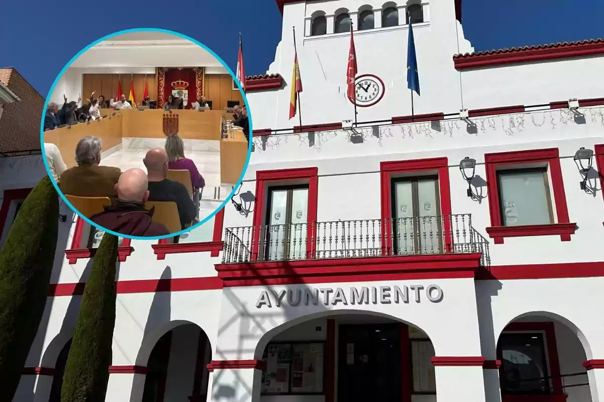 Fachada de un edificio de ayuntamiento blanco con detalles rojos y un reloj en la parte superior, sobre la imagen hay un círculo que muestra una reunión de personas en una sala de plenos